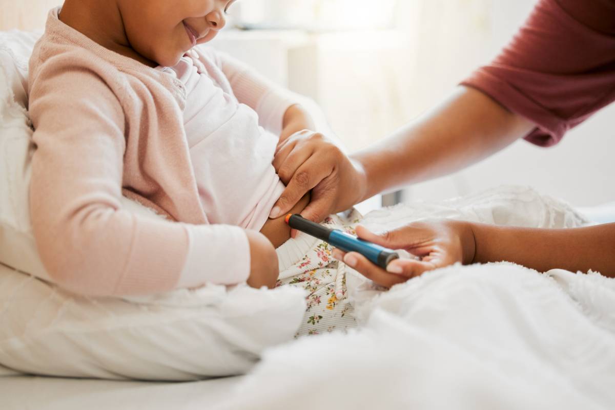 Stock image of Tiny Doctor Insert Sample with Blood into Digital Glucose Meter to Control Diabetes Sickness